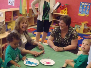 State Senator Gayle Manning and Ann Schloss from Elyria City Schools fingerpaint with children at Cascade Horizon Center