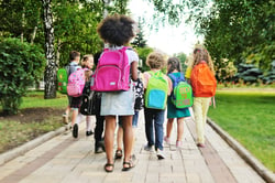 Children heading off to school with their backpacks.