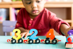 A toddler learning number and letter recogniton.