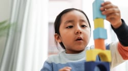 A toddler plays with blocks, which are a great tool for building a toddler's socialization skills.