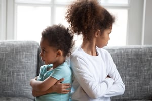 siblings sitting ignoring, turning away from each other with arms crossed, bad relationships between little preschooler sister and toddler brother, children conflict