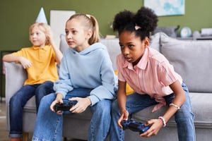 Teenage kids playing video games at home and having fun indoors, copy space