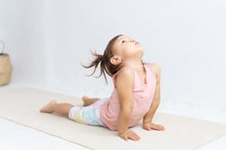 A preschool child does yoga for exercise